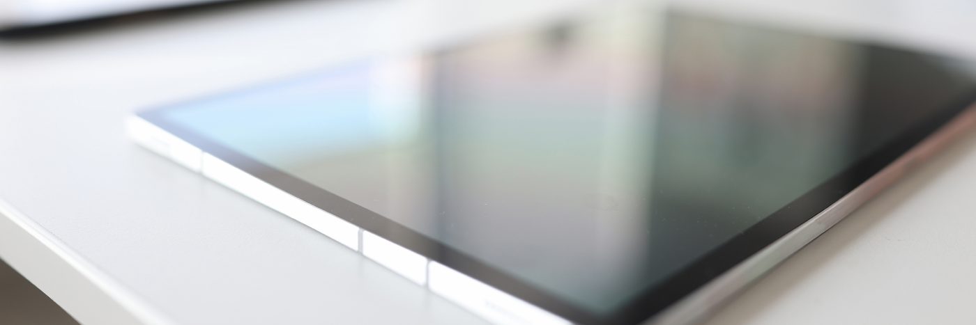 Modern digital tablet lies on table in background. Doing business online closeup